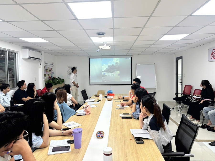 Ảnh chụp toàn cảnh phòng học, nhân viên chăm chú theo dõi màn hình máy chiếu video thực tế 

